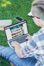 cropped shot of teenager using laptop with amazon website while sitting