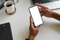 Cropped shot top view of businessman hands using smartphone mockup on office desk. Blank screen mobile phone for graphic display Royalty Free Stock Photo