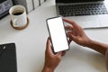 Cropped shot top view of businessman hands using smartphone mockup on office desk. Blank screen mobile phone for graphic display Royalty Free Stock Photo