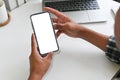 Cropped shot top view of businessman hands using smartphone mockup on office desk. Blank screen mobile phone for graphic display Royalty Free Stock Photo