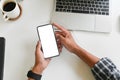 Cropped shot top view of businessman hands using smartphone mockup on office desk. Blank screen mobile phone for graphic display Royalty Free Stock Photo