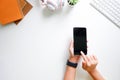 Cropped shot top view of hands using smartphone mockup at the white office desk. Blank screen mobile phone Royalty Free Stock Photo