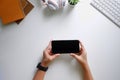 Cropped shot top view of women hands using smartphone mockup at the white office desk. mobile phone Royalty Free Stock Photo