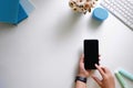 Cropped shot top view of hands using smartphone mockup at the white office desk. Blank screen mobile phone Royalty Free Stock Photo