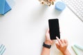 Cropped shot top view of women hands using smartphone mockup at the white office desk. mobile phone Royalty Free Stock Photo