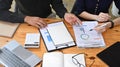 Two businesspeople analyzing financial graph together at office desk. Royalty Free Stock Photo