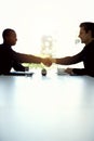 Theyve got a deal on the table to negotiate. Cropped shot of two businesspeople shaking hands in an office. Royalty Free Stock Photo