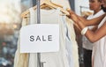 Shopping up a storm. Cropped shot of two women looking at dresses on a rail with a sign that reads sale. Royalty Free Stock Photo