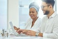 Two heads are always better than one. Cropped shot of two young diverse businesspeople working together on a laptop in Royalty Free Stock Photo