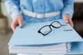 Cropped shot of unrecognisable business woman in blue formal shirt holding full folder of financial documents, selective Royalty Free Stock Photo