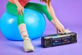 Cropped shot of unrecognizable fitness woman turns on her retro portable cassette player