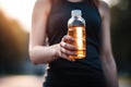 cropped shot of an unrecognizable woman holding up a plastic bottle with the cap on