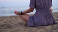 Cropped shot of unrecognizable young woman meditating on beach Royalty Free Stock Photo