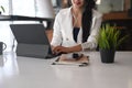 Businesswoman weraing earphone working on laptop computer at office.