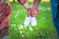 Cropped shot view of expecting parents holding baby shoes. Pregnancy, maternity and new family concept.