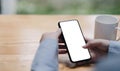 Cropped shot view of woman hands holding smart phone with blank copy space screen for your text message or information content, Royalty Free Stock Photo