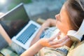Cropped shot view of young teen girl keyboarding on laptop computer with blank copy space screen while sitting in garden Royalty Free Stock Photo