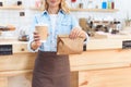 cropped shot of waitress holding coffee to go in paper cup and take away food Royalty Free Stock Photo