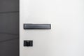 Black matt door handle on white wooden door