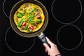 cropped shot of woman cooking omelette in frying pan