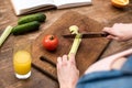 cropped shot of woman cutting celery on wooden