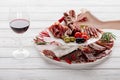 Cropped shot of woman, glass of red wine and meat snacks Royalty Free Stock Photo