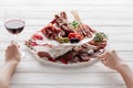 Cropped shot of woman, glass of red wine and meat snacks Royalty Free Stock Photo