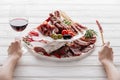 Cropped shot of woman, glass of red wine and meat snacks Royalty Free Stock Photo