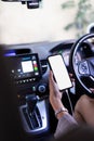 Cropped shot of woman hand using mockup white screen smartphone while driving a car. clipping path Royalty Free Stock Photo