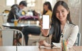 Cropped shot of a Woman holding a blank screen smartphone to the front.She offers a insurance package to cover virus infection