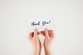 cropped shot of woman holding paper with thank you lettering in hands