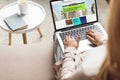 cropped shot of woman at home sitting on couch and using laptop with bbc