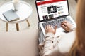 cropped shot of woman at home sitting on couch and using laptop with bbc news