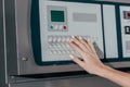 cropped shot of woman pressing buttons on industrial washing machine