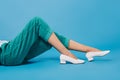 cropped shot of woman in stylish pants and shoes lying on floor