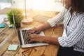 Making money is not that hard anymore. Cropped shot of a woman using her laptop on a wooden table. Royalty Free Stock Photo