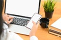 Cropped shot woman working with empty mobile phone and blank screen laptop computer. Royalty Free Stock Photo