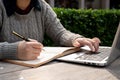 A cropped shot of a woman working on her business tasks at a table outdoors Royalty Free Stock Photo