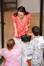 Halloween in a friendly neighbourhood. Cropped shot of a woman handing out candy to two little trick-or-treaters. Royalty Free Stock Photo