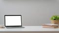 Cropped shot of workplace with mock up laptop, coffee cup, office supplies and decorations on white table Royalty Free Stock Photo