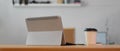 Workspace with digital tablet, schedule book and paper cup on wooden table