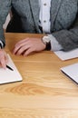 Cropped shot of workspace with man's hands with watch and work s