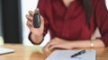 Cropped shot of young confidence girl smiling and showing the key while sitting at the work desk. Royalty Free Stock Photo