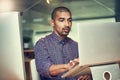 Powering through all his deadlines. Cropped shot of a young designer working late on a laptop in an office.