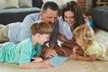 Using apps together as a family. Cropped shot of a young family using a tablet together on the floor in the living room