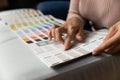 Close up of young woman houseowner select interior paint tone