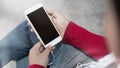 Cropped shot young female using mobile phone and earphones Royalty Free Stock Photo