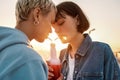 Cropped shot of young lesbian couple having romantic moment, drinking from one glass bottle with the straw, Two women Royalty Free Stock Photo