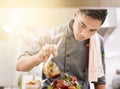 The final touch. Cropped shot of a young male chef cooking in his kitchen. Royalty Free Stock Photo