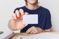 Cropped shot of young male hands holds blank card with copy space for your text or advertising content. Young businessman wears t Royalty Free Stock Photo